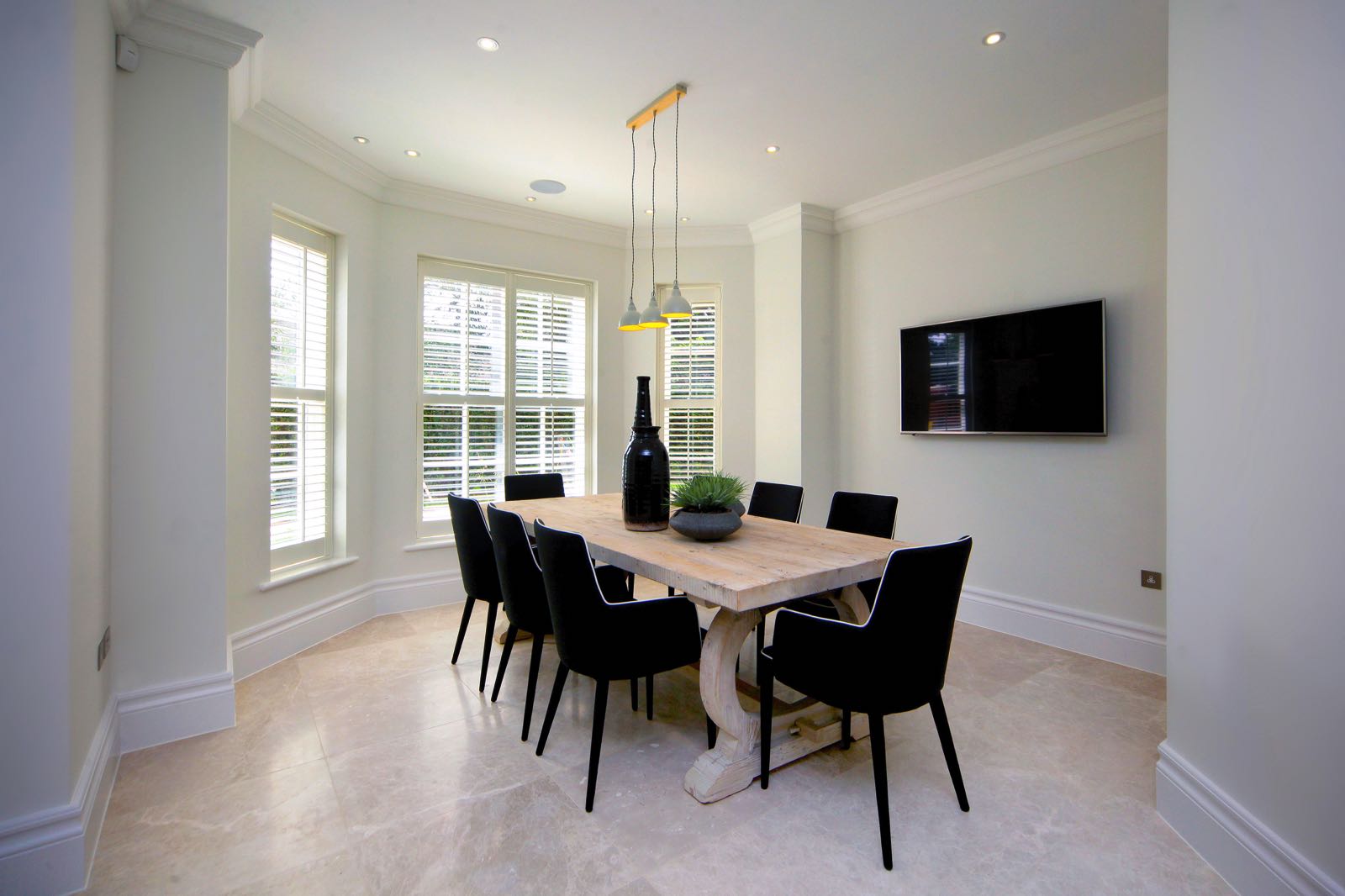 Modern dinning room with bay window wooden shutters in Barnet home