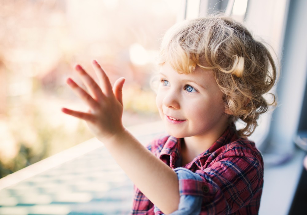 Young girl touching glass